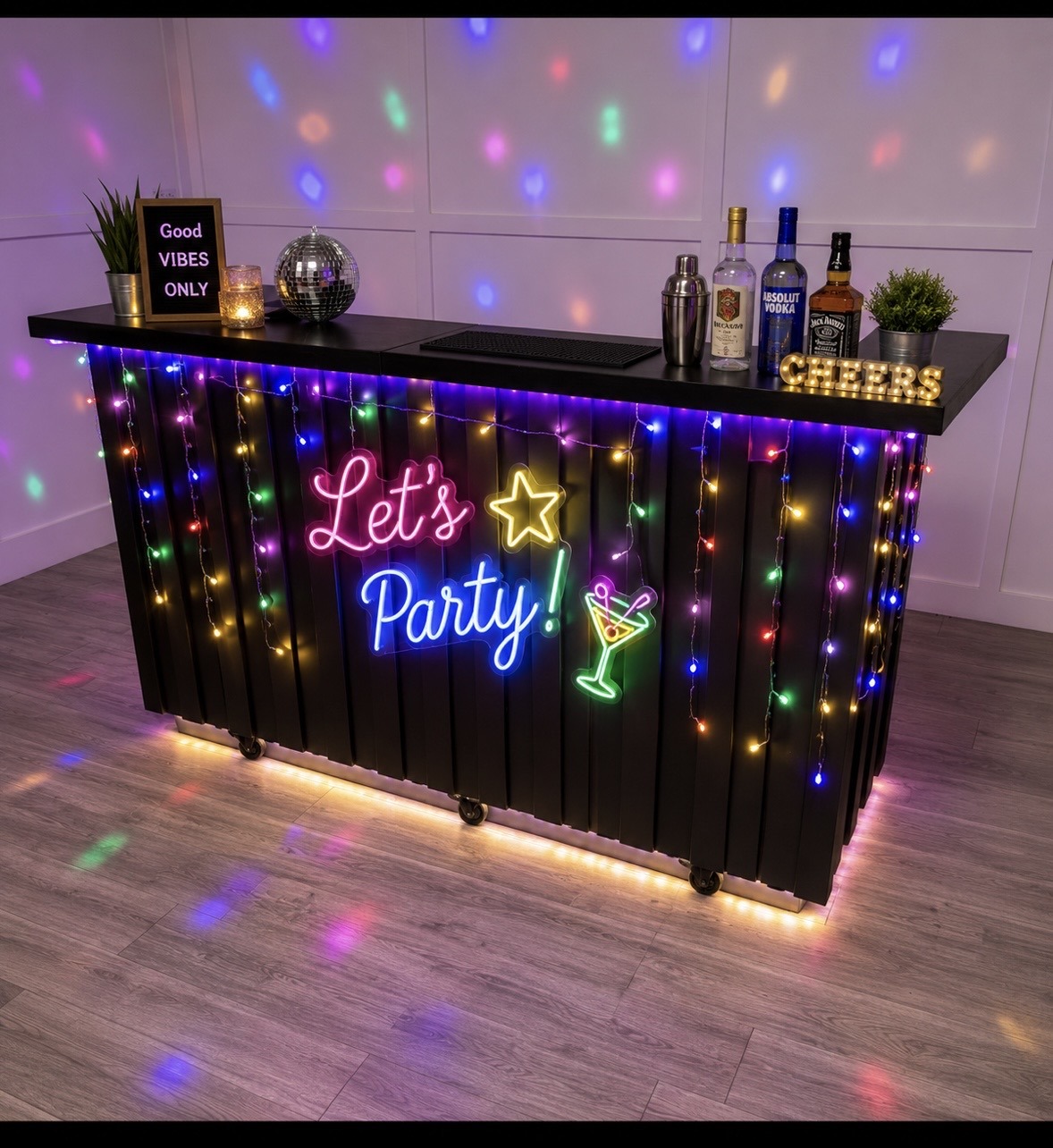 Festive bar setup with colorful LED lights, a "Let's Party!" neon sign