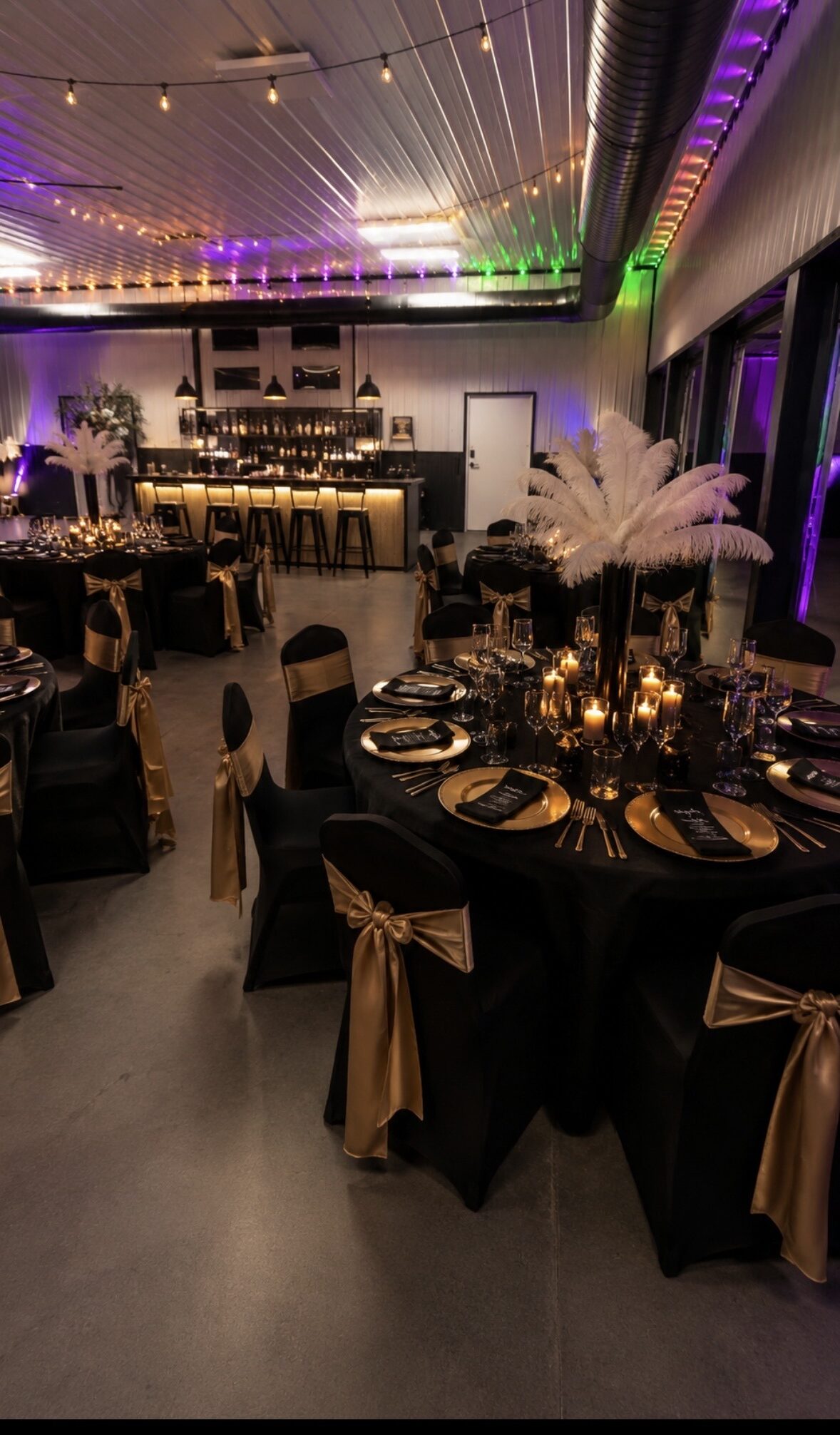 Elegantly decorated banquet hall featuring black and gold tables,